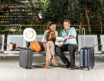 Couple assis sur un banc d'aéroport